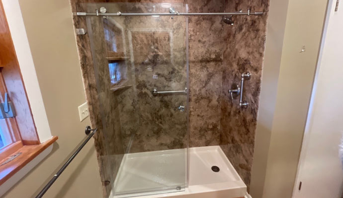 A modern shower enclosure with marble walls